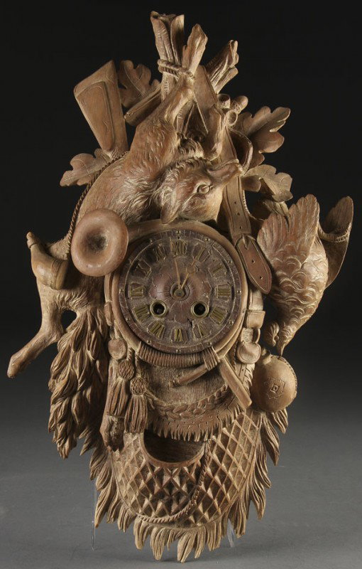 SWISS CARVED BLACK FOREST WALNUT CUCKOO CLOCK: A SWISS CARVED BLACK FOREST WALNUT CUCKOO CLOCK early 20th century, with hunting motif of game including a fox. Height 22 inches.