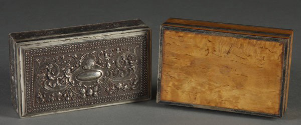 SILVER MOUNTED CIGARETTE BOXES: A PAIR OF 19TH C. CONTINENTAL SILVER MOUNTED CIGARETTE BOXES one in figured birch with silvered frame and jeweled thumbpiece; the other with chased and repoussed silver overlay. Each with indistinguis