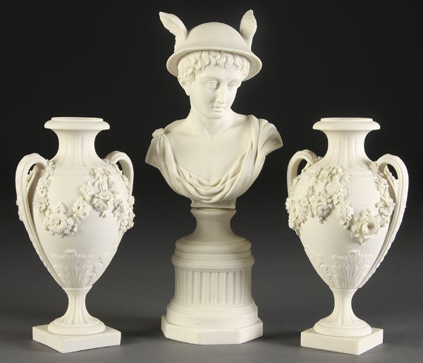 3 PC PARIAN PORCELAIN GROUP: A 3-PIECE PARIAN PORCELAIN GROUP circa 1900. Consisting of 2 floral encrusted handled urns and a bust of Mercury raised on a socle pedestal. All apparently unmarked. Largest height 13.75 inches.