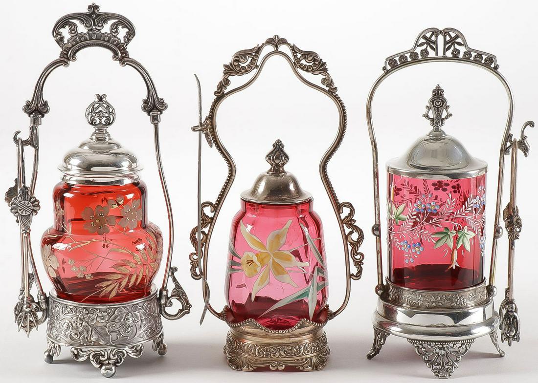 THREE VICTORIAN CRANBERRY CASTORS: THREE VICTORIAN CRANBERRY CASTORS. Comprising three individual cranberry castors, each with enameled inserts held in silver plated frames, including a Barbour, a Rogers, and a Meriden. Greatest height