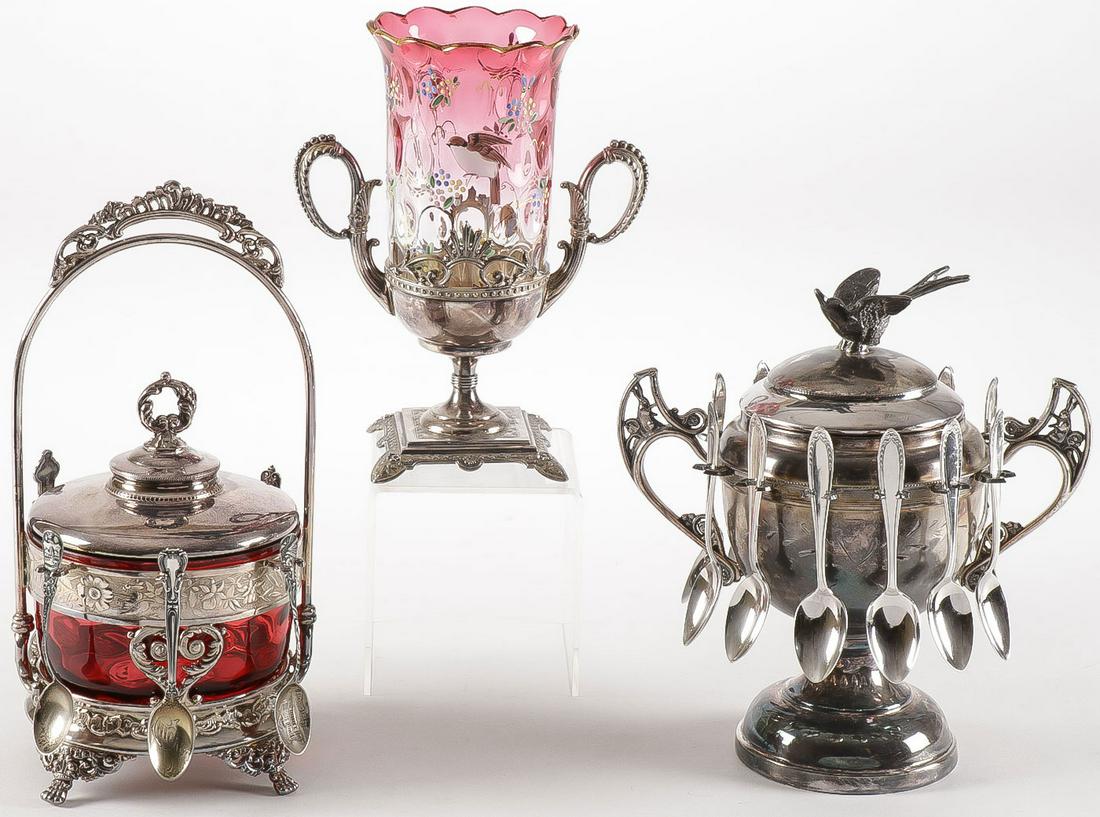 VICTORIAN TABLEWARE: VICTORIAN TABLEWARE. Comprising a thumb spot amberina enameled spooner insert in a silver-plated frame, an ornate sugar bowl with cranberry thumb print insert and fitted lid, and a trophy style silver