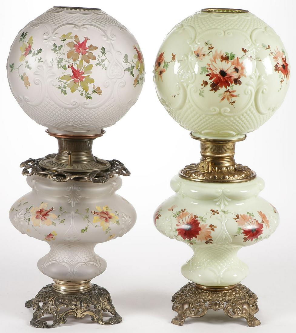 PAIR CONSOLIDATED PARLOR LAMPS: PAIR CONSOLIDATED PARLOR LAMPS. Both in Oxford pattern, one in crystal satin finish, the other in custard. Both with hand decorated flowers, and neither electrified. Height 24 inches. SHIPPING NOTICE: