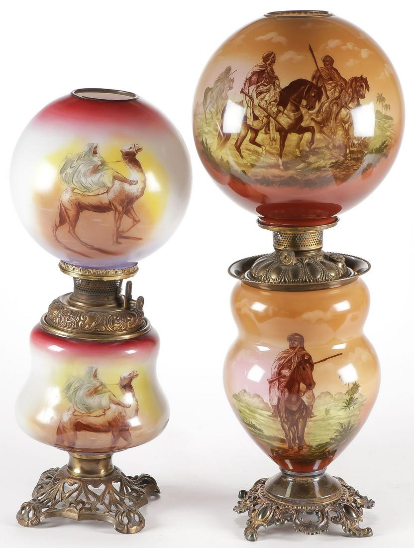 PAIR OF ARAB GWTW PARLOR LAMPS, C. 1910: PAIR OF ARAB GWTW PARLOR LAMPS, C. 1910. The smaller lamp depicting an Arab on camel, the larger lamp depicting armed Arabs on horseback. One electrified. Greatest height 27 inches. SHIPPING NOTICE: J