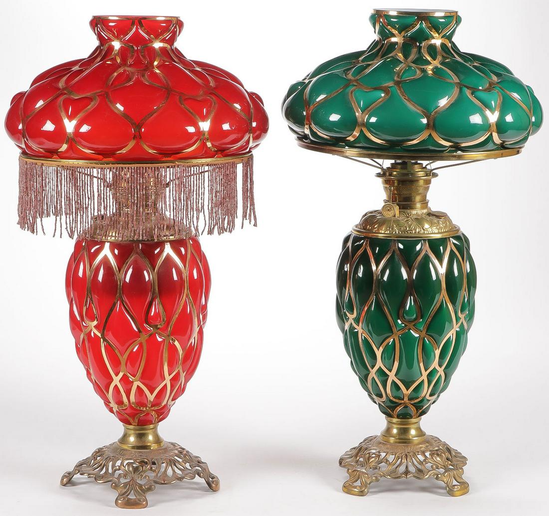 GREAT PAIR VICTORIAN PARLOR LAMPS: GREAT PAIR VICTORIAN PARLOR LAMPS. With matching brass bases, each in blown out fishnet pattern with gilt tracing, one in green cased glass, the other in red glossy finish. Both approximately 26 inche