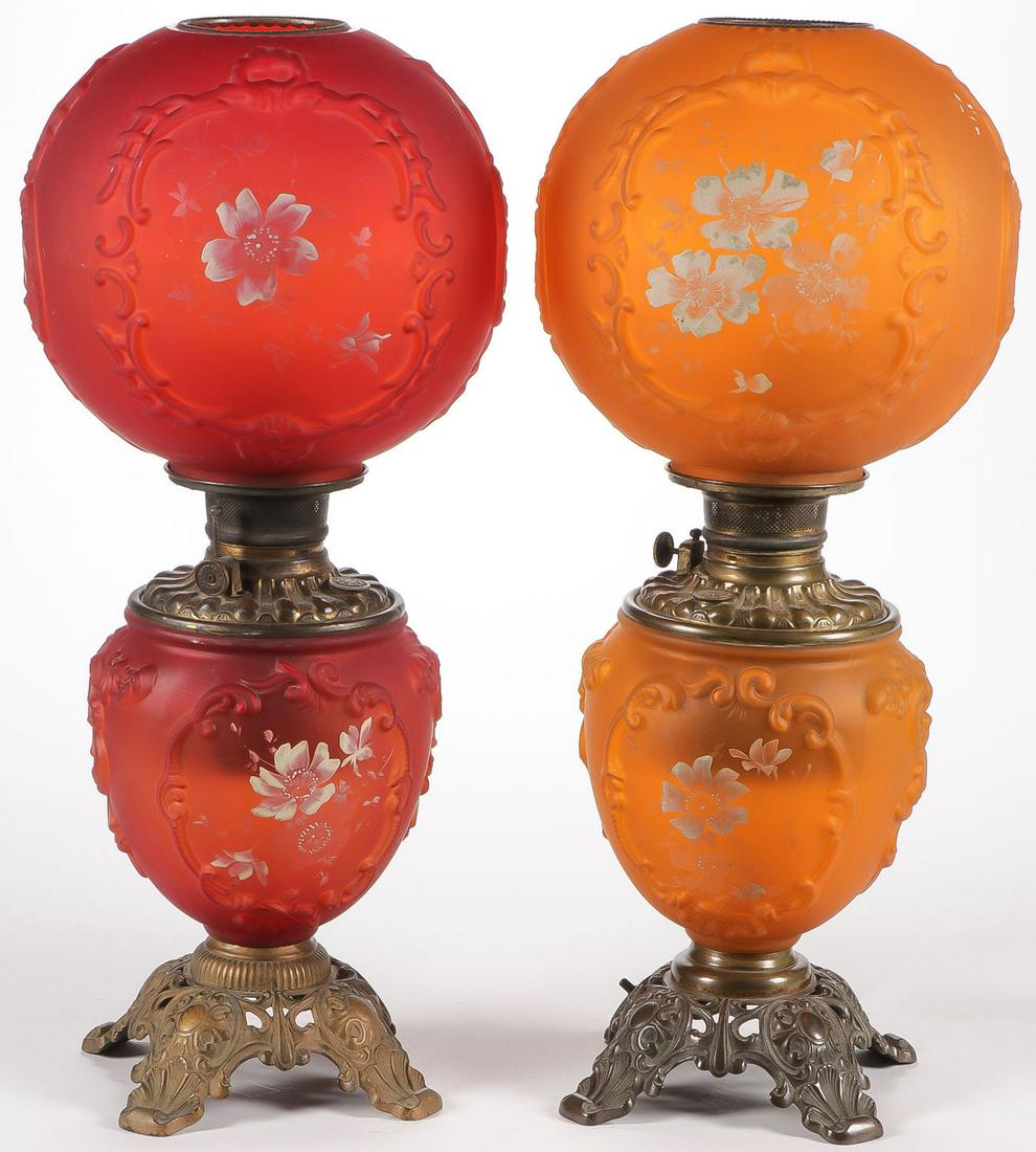 PAIR CONSOLIDATED PARLOR LAMPS C. 1902: PAIR CONSOLIDATED PARLOR LAMPS C. 1902. With matching bases, one in orange satin pattern glass No. 24 (electrified), the other in red satin pattern glass No. 24. Height 23.25 inches. SHIPPING NOTICE: