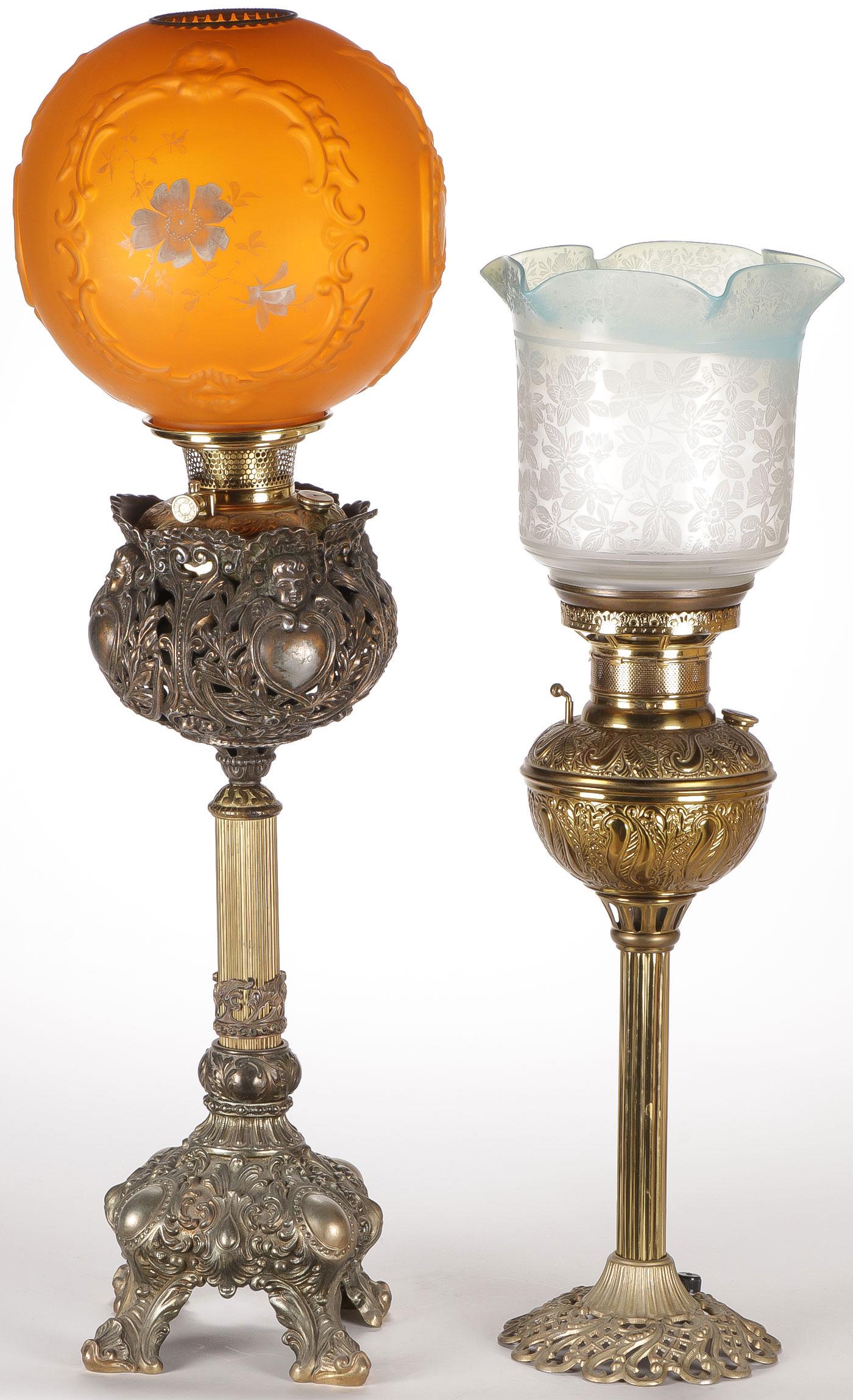 PAIR VICTORIAN PARLOR LAMPS, 19TH C: PAIR VICTORIAN PARLOR LAMPS, 19TH C. Including a large and impressive example with fluted column base and cherub head font reservoir displaying a hand-painted satin glass shade, the other with etched 