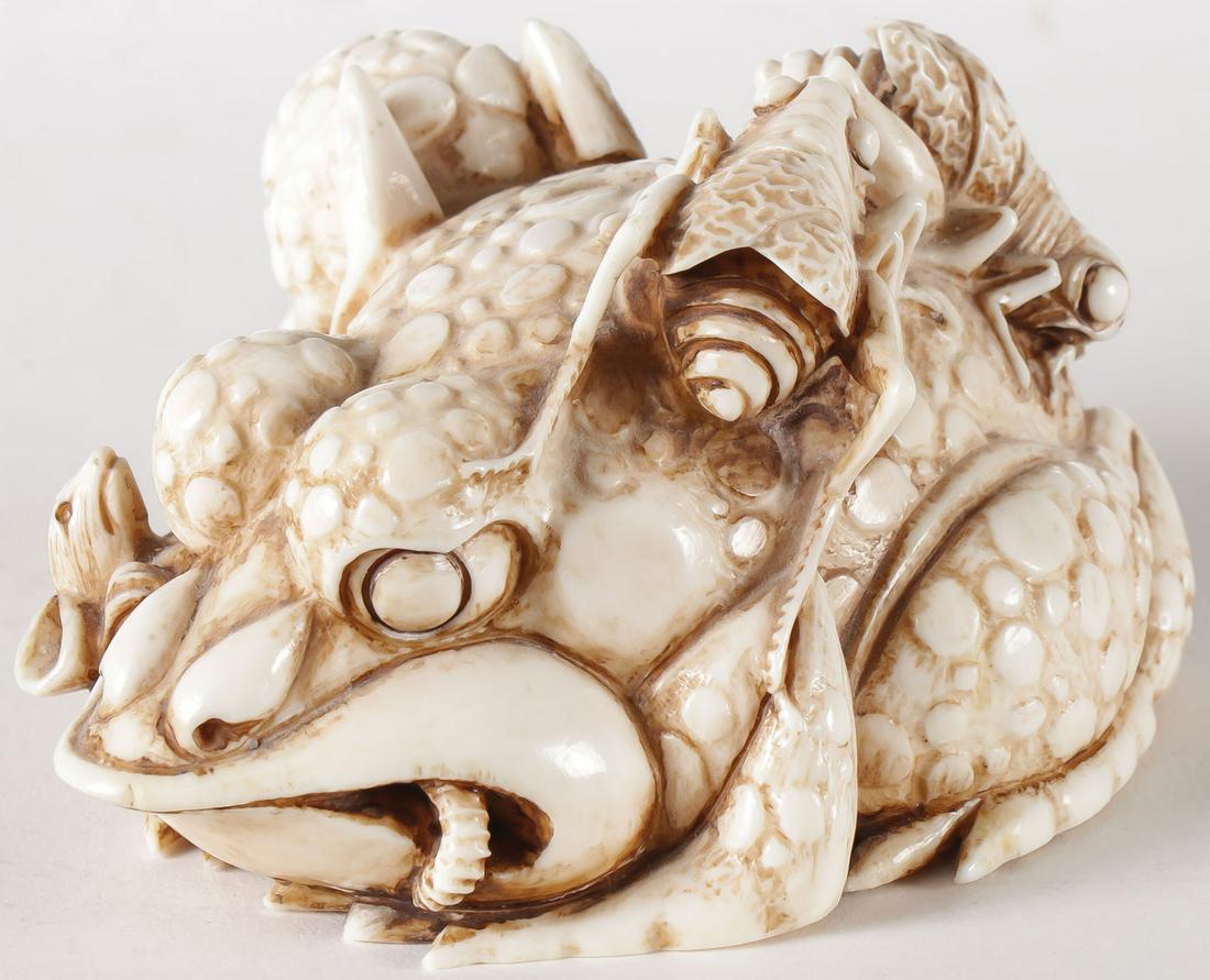IMPRESSIVE CARVED JAPANESE TOAD AND INSECTS: IMPRESSIVE CARVED JAPANESE TOAD AND INSECTS, C. 1920. Comprising a large and impressive carved toad eating a rat and on his back two crickets. Underside with two string holes. Length 4 inches. NO INTE