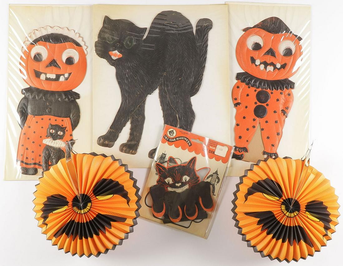 NEAR MINT HALLOWEEN PAPER DECORATIONS: NEAR MINT HALLOWEEN PAPER DECORATIONS. Including relief press molded die cut cat, Mr. and Mrs. Jack-o-Lantern, both with strut stands, a cat dancer, and two crepe paper fold-together jack-o-lanterns.