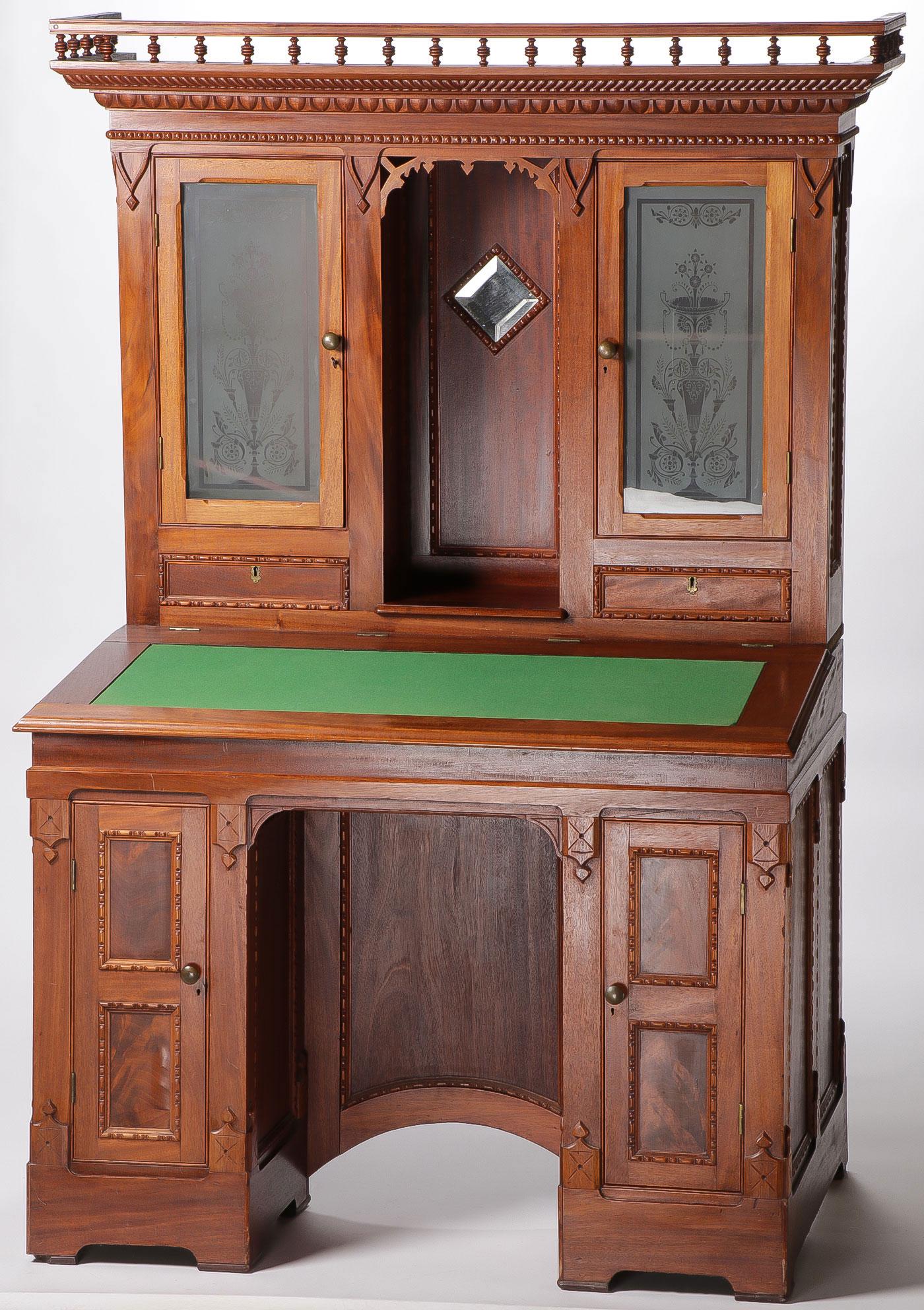 A WALNUT VICTORIAN WRITING DESK: A WALNUT VICTORIAN WRITING DESK. Comprising a two sectioned desk set with turned decorated balcony above two etched glass doors set top a felt writing surface and a two doored lower section. 66 inches