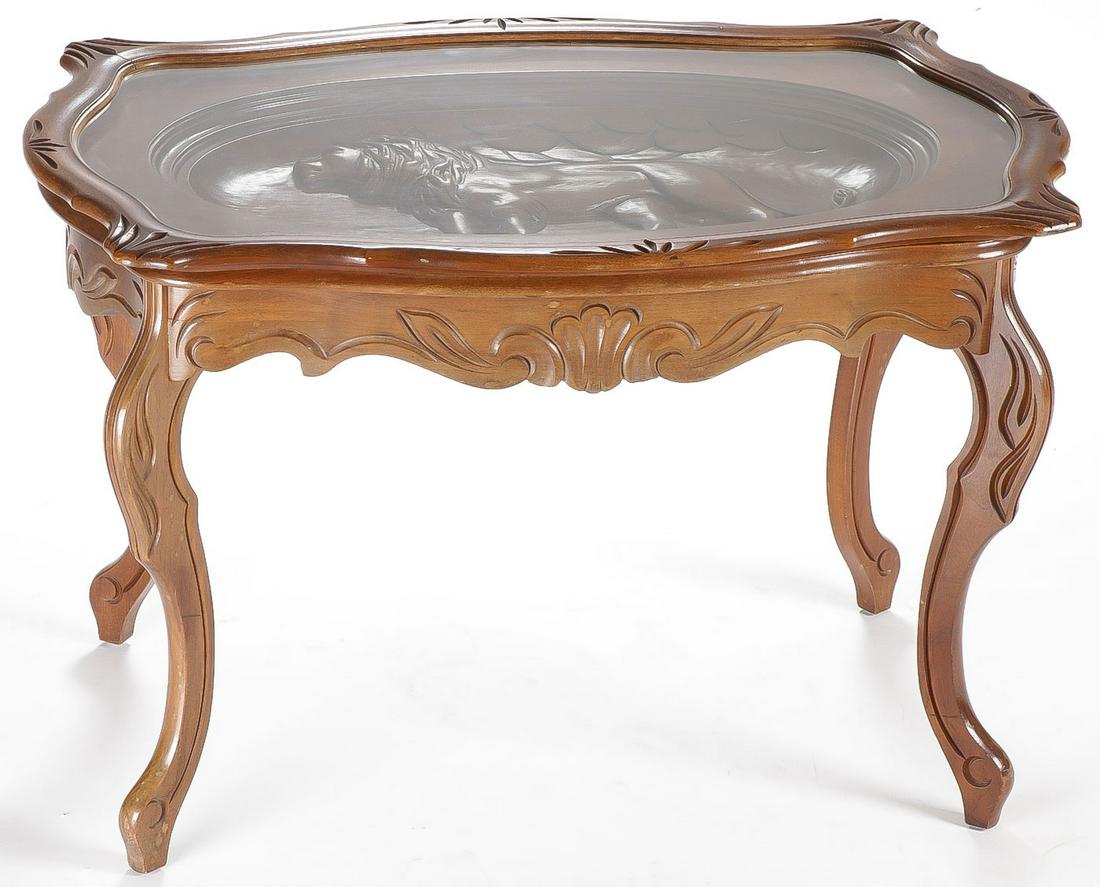 A CARVED GLASS-TOP TRAY TABLE: A CARVED GLASS-TOP TRAY TABLE. Comprising an ornately carved coffee or tea table depicting a lion with carved apron and four cabriole legs set on top with a conforming and removable glass tray. 19.5 i
