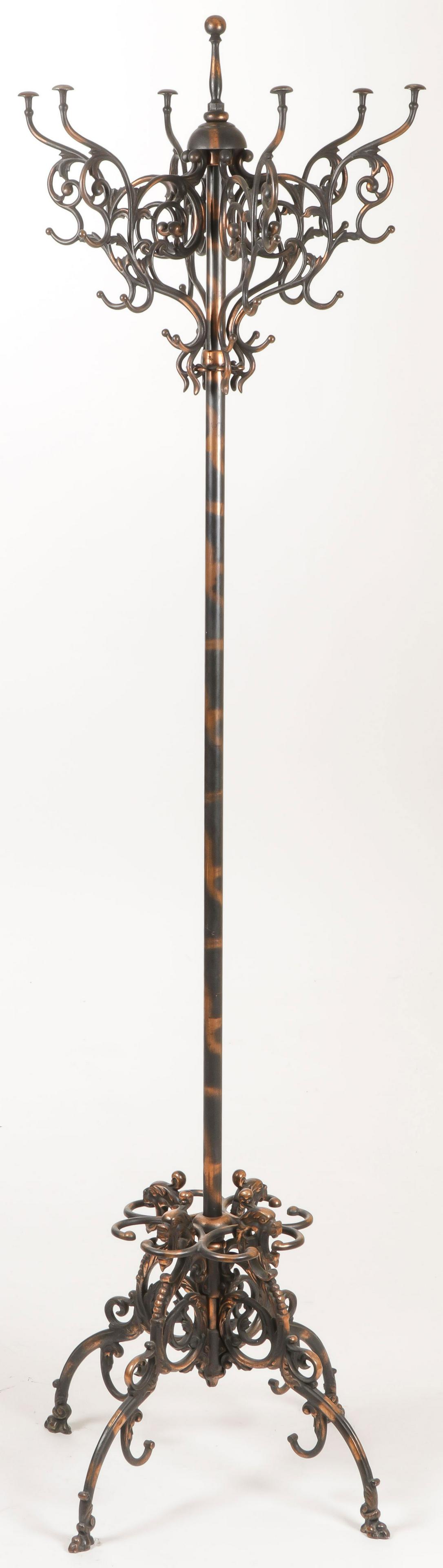 IRON HALL TREE & UMBRELLA STAND W/ COPPER FLASH: AN IRON HALL TREE & UMBRELLA STAND WITH COPPER FLASH. Comprising an ornately formed coat rack above a single pole giving way to four beast form legs terminating in paw feet. Height 73 inches.SHIPPING