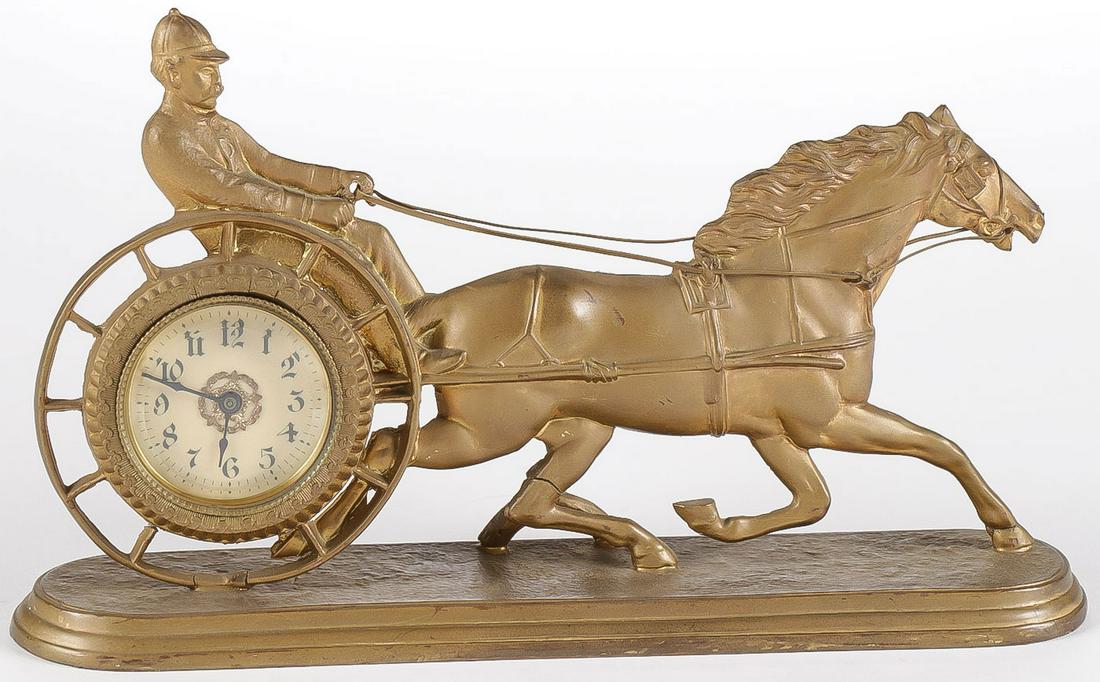 SCARCE SULKY GILT DESK CLOCK: SCARCE SULKY GILT DESK CLOCK. Comprising a sulky figural gilt metal desk clock sculpted in half round, underside of base indistinctly marked Moore and Company. Length 10.25 inches. SHIPPING NOTICE: Ja