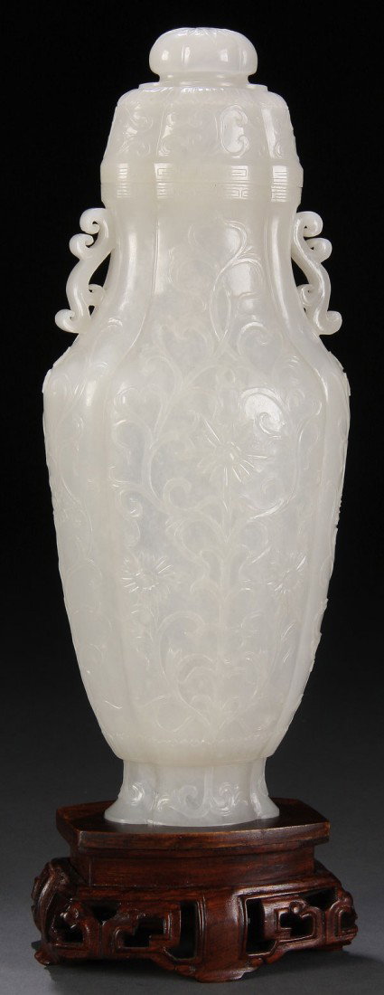 CHINESE MUGHAL STYLE CARVED WHITE JADE VASE, QING: AN EXTREMELY FINE CHINESE MUGHAL STYLE CARVED WHITE JADE LIDDED HU-FORM VASE, QING DYNASTY. The evenly toned semi translucent white jade flat sided and well hollowed vase raised on flared petal form f