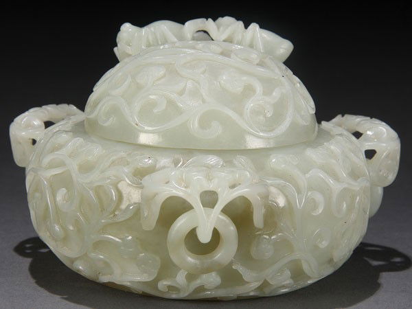 CHINESE CARVED WHITE JADE MUGHAL STYLE POT QING: A CHINESE CARVED WHITE JADE MUGHAL STYLE LIDDED POT, QING DYNASTY, LATE 18TH CENTURY. The diminutive compressed globular form in an evenly toned semi-translucent jade with three openwork foliate handl