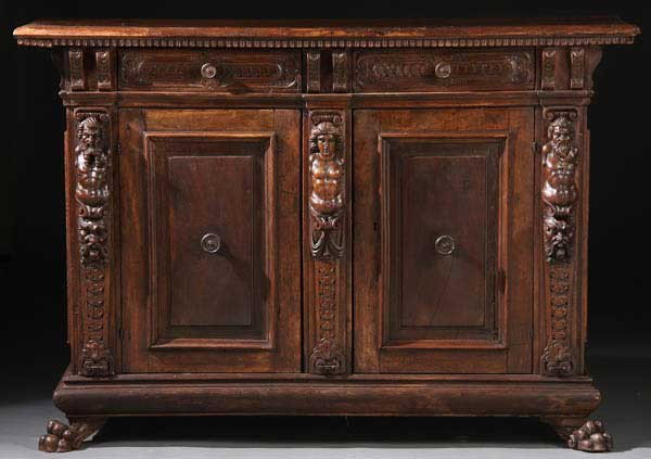 ITALIAN RENAISSANCE CARVED WALNUT CREDENZA: A VERY FINE ITALIAN RENAISSANCE CARVED WALNUT CREDENZA, 17TH CENTURY, PROBABLY TUSCAN. With later restorations and elements. With two paneled doors, each flanked by figural carved caryatids above grot