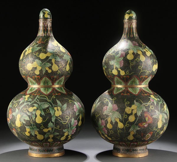 CHINESE CLOISONNE AND GILT BRONZE VASES: A PAIR OF LARGE CHINESE CLOISONNE AND GILT BRONZE LIDDED BOTTLE VASES, 20TH CENTURY, of double gourd form decorated allover with yellow double gourds, bats. Butterflies and peony blossoms on a dark gr