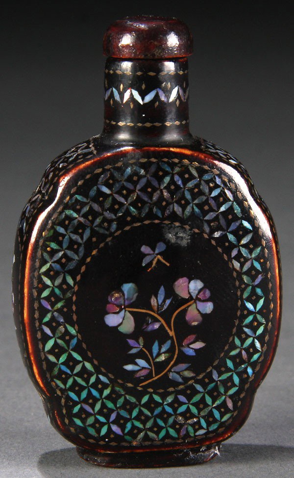CHINESE LACQUER & PAUA SHELL INLAID SNUFF BOTTLE: A CHINESE LACQUER AND PAUA SHELL INLAID SNUFF BOTTLE, QING DYNASTY/EARLY REPUBLIC PERIOD, of flattened ovoid form with shaped shoulders raised on a diminutive foot in dark reddish brown lacquer inlaid