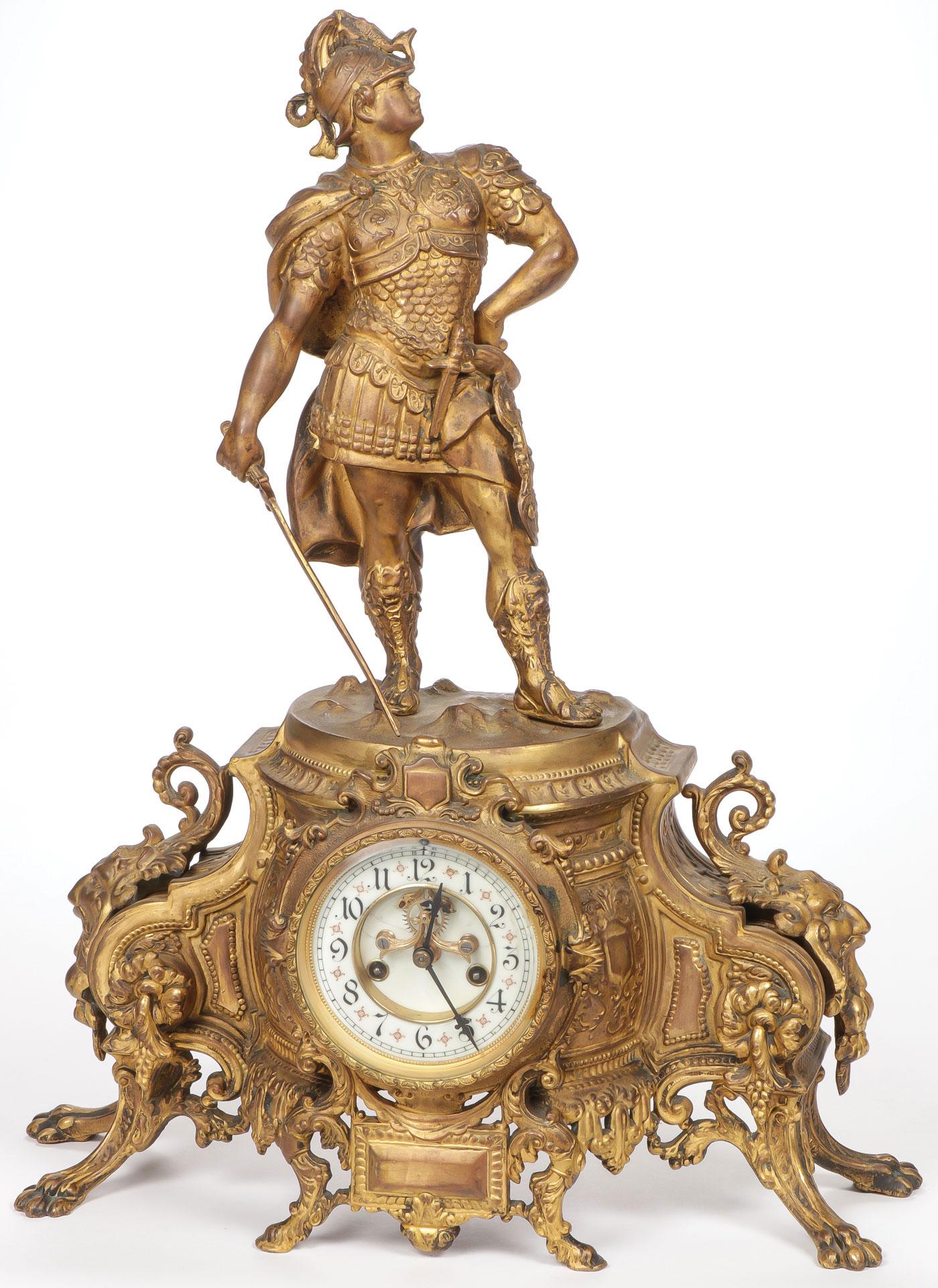GREAT WATERBURY FIGURAL MANTEL CLOCK C. 1900: GREAT WATERBURY FIGURAL MANTEL CLOCK C. 1900. Comprising a large and impressive gilt metal figural clock resting on paw and hove feet with elaborate scroll foliage and masks supporting a Roman soldier