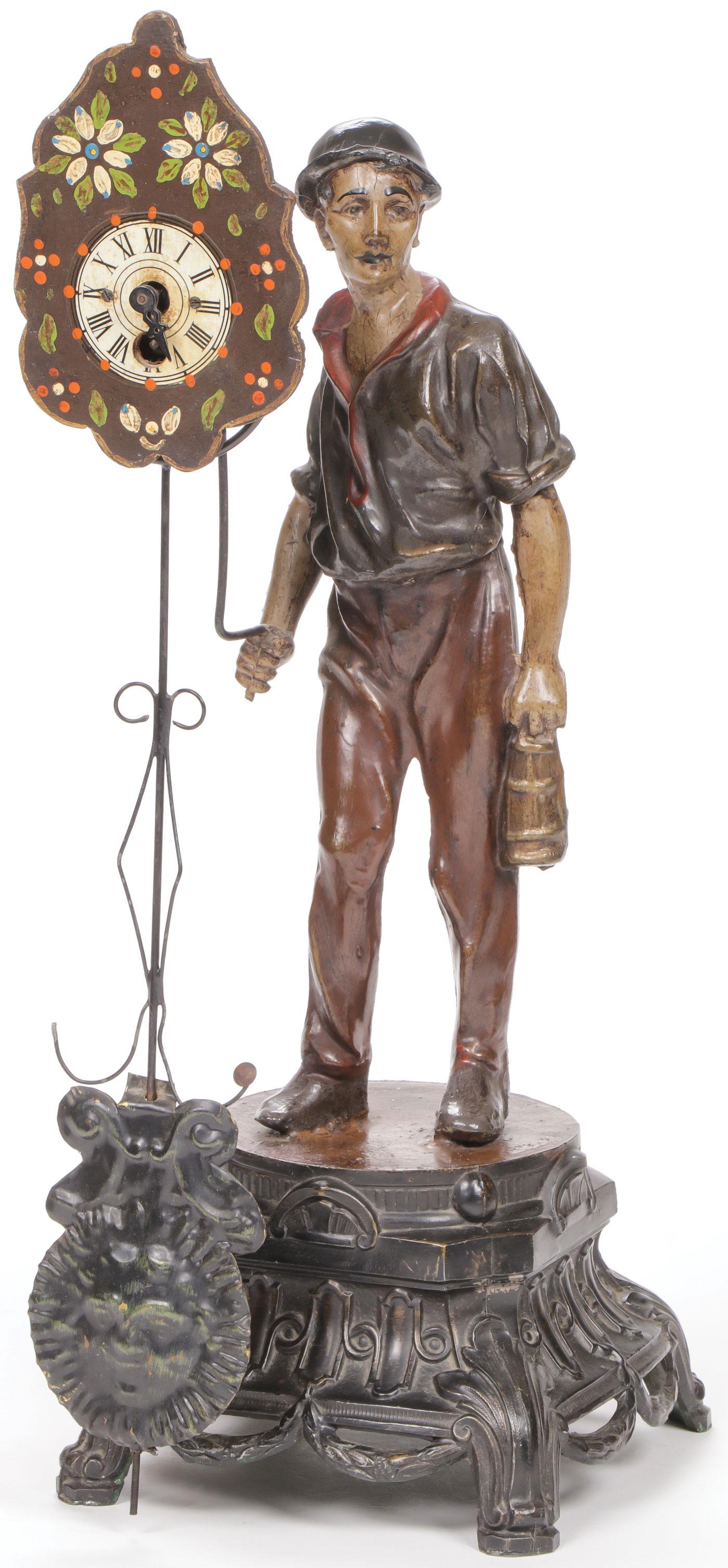INTERESTING FIGURAL MYSTERY CLOCK: INTERESTING FIGURAL MYSTERY CLOCK. Comprising a polychrome zinc figure of a miner holding a lantern and in his right hand a bracket upon which rests a mystery pendulum clock. Overall height 17.75 inch