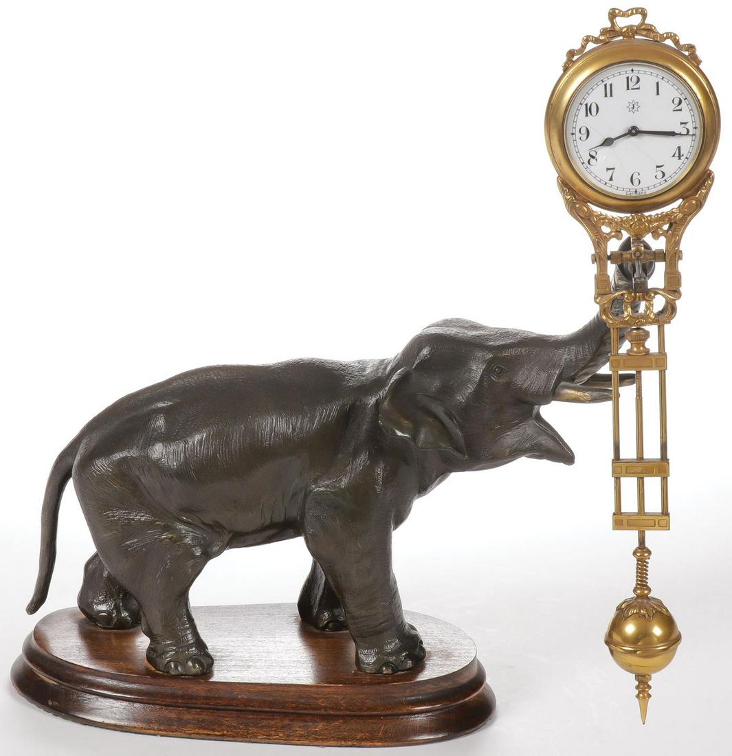 A JUNGHANS ELEPHANT MYSTERY CLOCK: A JUNGHANS ELEPHANT MYSTERY CLOCK. A finely modeled patinated metal elephant on original wooden plinth with gilt metal swinging pendulum mystery clock. Height 11.25 inches.SHIPPING NOTICE:Jackson