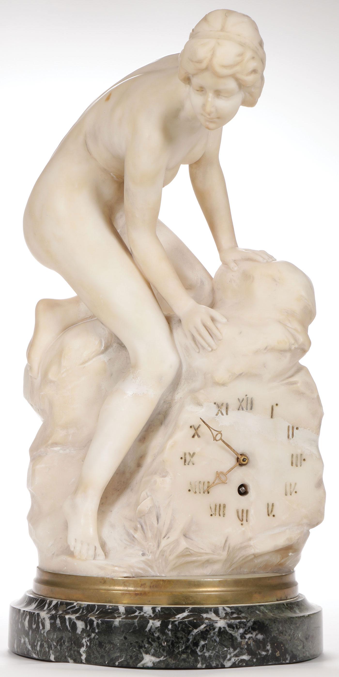 CARVED MARBLE FIGURAL CLOCK C. 1895: CARVED MARBLE FIGURAL CLOCK C. 1895. Depicting a beautifully carved nude female on a rocky outcrop which incorporates a carved clock face with Roman numerals resting on a raised marble base and the in