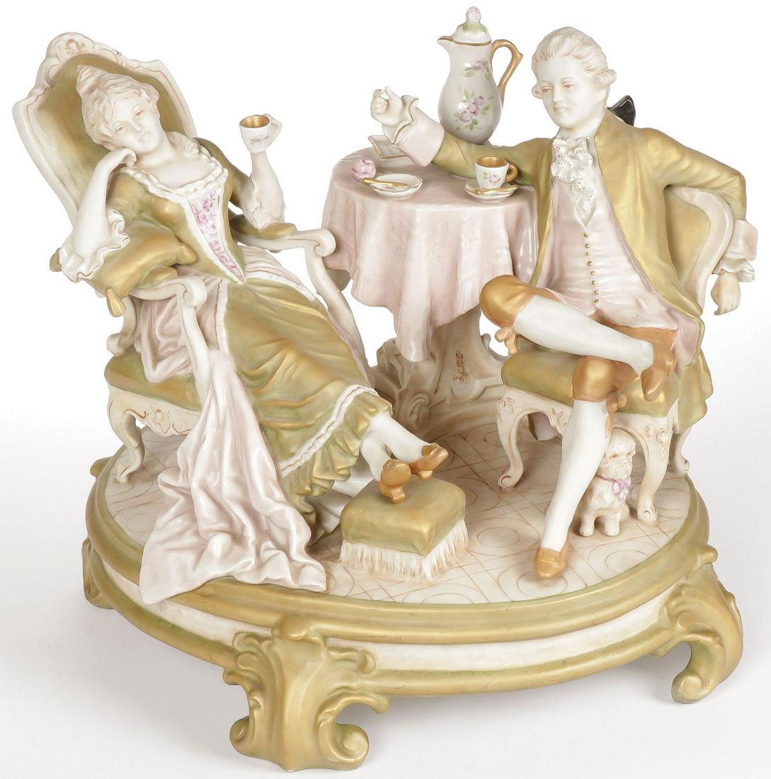 LARGE ROYAL DUX FIGURAL GROUPING: LARGE ROYAL DUX FIGURAL GROUPING. Comprising a large and impressive porcelain group of a man and a woman enjoying a leisurely cup of tea, dressed in 18th century costume, and traditional Royal Dux iri