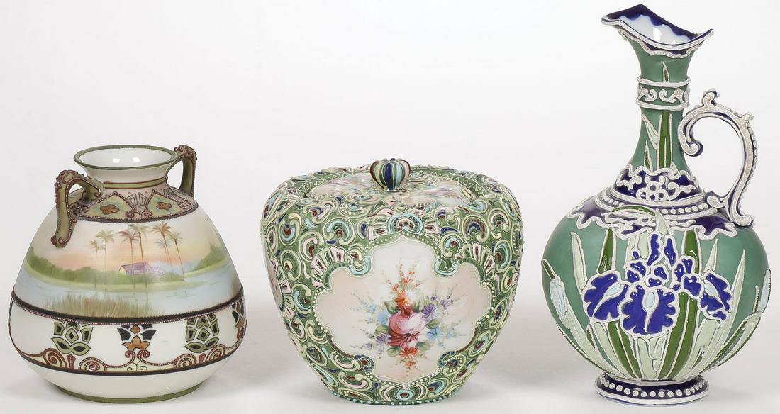 THREE NIPPON MORIAGE DECORATED PIECES: THREE NIPPON MORIAGE DECORATED PIECES. Comprising an ewer, a covered biscuit jar and a two handled vase with wreath mark. Greatest height 9.5 inches. SHIPPING NOTICE: Jackson's is your sole and on