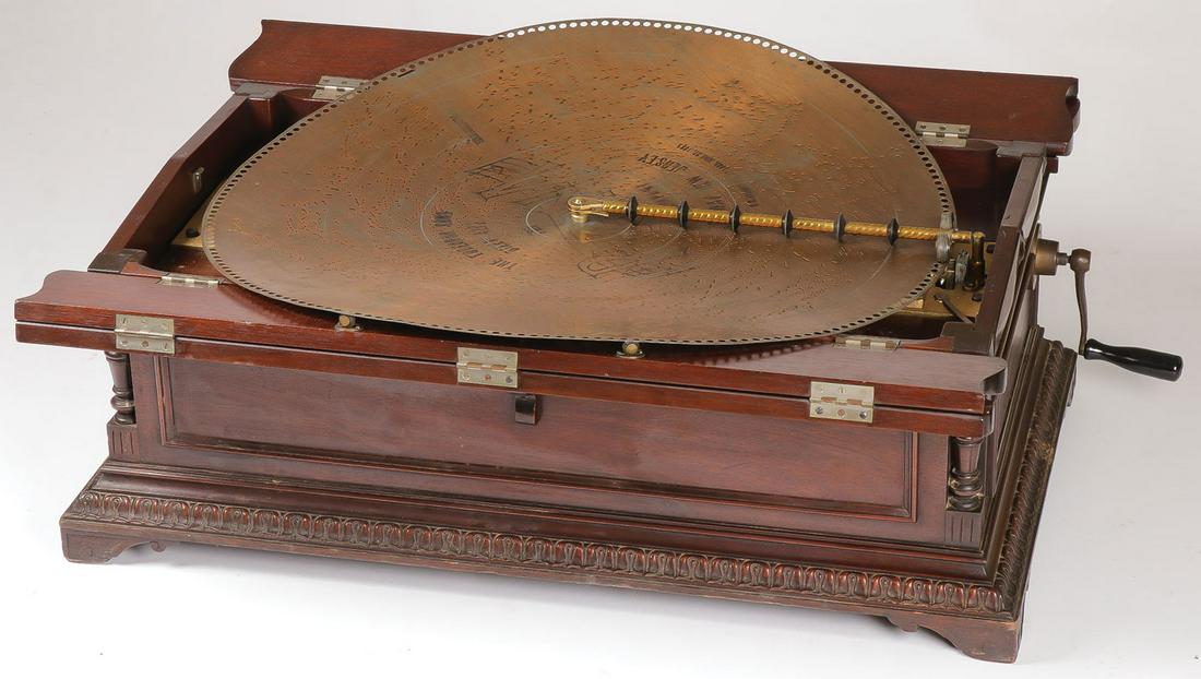 A LARGE REGINA TABLE TOP DISC MUSIC BOX CIRCA 190: A LARGE REGINA TABLE TOP DISC MUSIC BOX CIRCA 1902. The mahogany case raised on bracket feet, with baluster turned corners and acanthus banding, the multi-hinged lid opening to reveal a two comb a