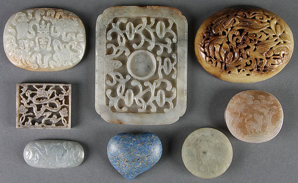 SEVEN CHINESE CARVED JADE AND HARDSTONE ORNAMENTS: SEVEN CHINESE CARVED JADE AND HARDSTONE ORNAMENTS, 19TH/20TH CENTURY. Comprising a carved nephrite oval plaque with Buddhist symbols, a gray nephrite plaque with dragon, two carved jade ornaments, an 