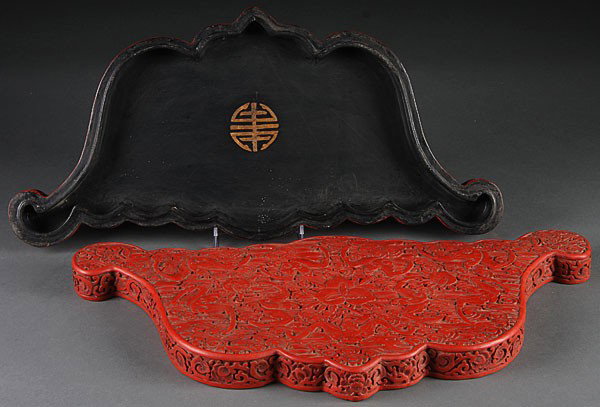 A CHINESE BAT FORM CARVED CINNABAR LIDDED BOX, EA: A CHINESE BAT FORM CARVED CINNABAR LIDDED BOX, EARLY 20TH CENTURY, the lid finely carved with nine flying bats, stylized clouds and peaches. Length 18.5 inches (47 cm).