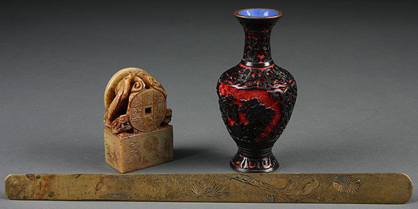 A THREE-PIECE ORIENTAL DECORATIVE ARTS GROUP, 20T: A THREE-PIECE ORIENTAL DECORATIVE ARTS GROUP, 20TH CENTURY, consisting of a Chinese black and red cinnabar vase, a carved soapstone seal with dragons, and a Japanese gilt-bronze letter knife with carv