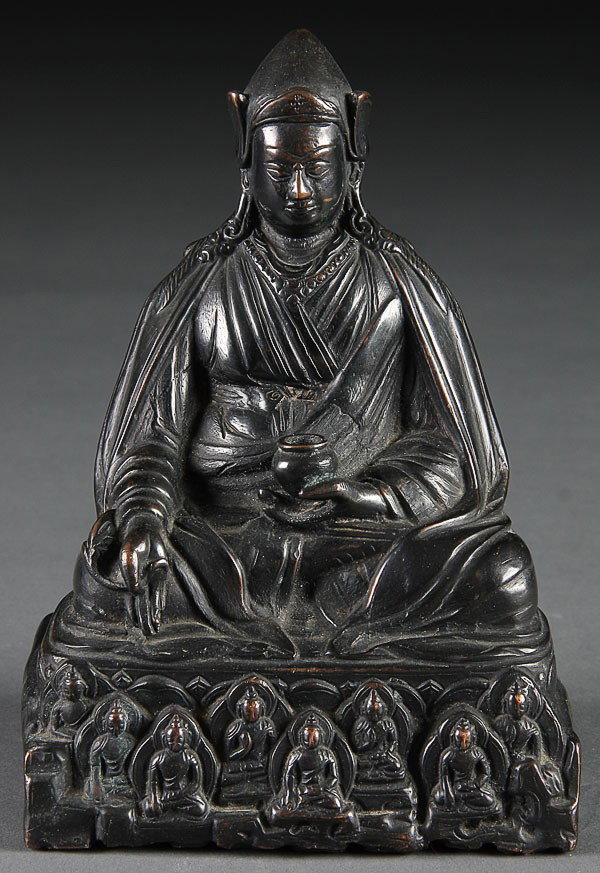 A SINO-TIBETAN BRONZE FIGURE OF A DEITY, 20TH CEN: A SINO-TIBETAN BRONZE FIGURE OF A DEITY, 20TH CENTURY. Of seated form depicted on a raised plinth with urn held in left hand, embossed rosette on base. Height 6 inches (15.5 cm).