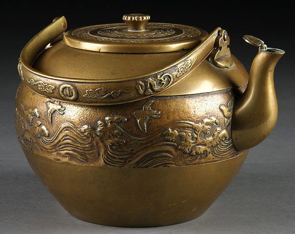 A JAPANESE BRONZE TETSUBIN AND MIXED METAL VASE, : A JAPANESE BRONZE TETSUBIN AND MIXED METAL VASE, EARLY 20TH CENTURY. The tetsubin (tea kettle) decorated with an embossed panel scene of birds above wavy seas with inlaid incised signature block on li