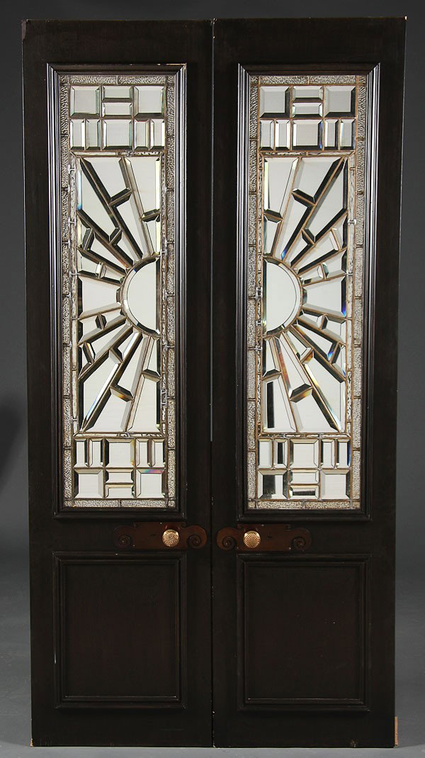 PAIR OF VICTORIAN LEADED AND BEVELED MIRROR PANELS: A FINE PAIR OF VICTORIAN LEADED AND BEVELED MIRROR GLASS PANELS, mounted in later ebonized paneled wood doors. Overall height 94 inches x 24 inches, the mirrored panels 56 inches x 15 inches each.