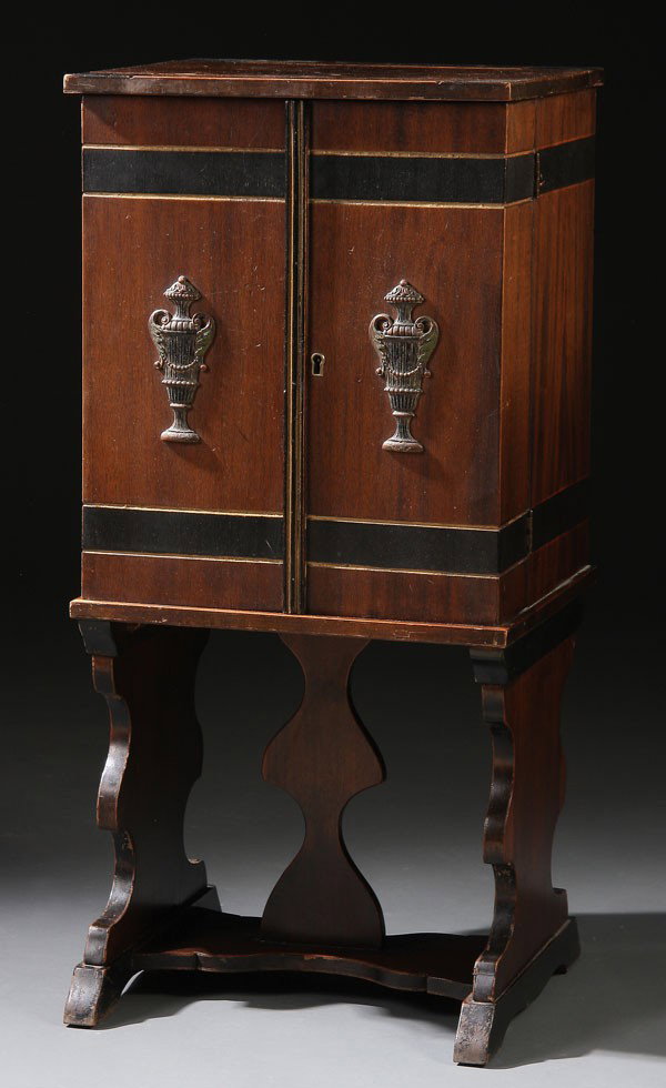 A WALNUT HUMIDOR/ SMOKING CABINET, with fold out : A WALNUT HUMIDOR/ SMOKING CABINET, with fold out wing doors opening to reveal a lined humidor with match holders raised on a trestle base, circa 1930s. Height 24 inches, width 16 inches, depth 14 inch