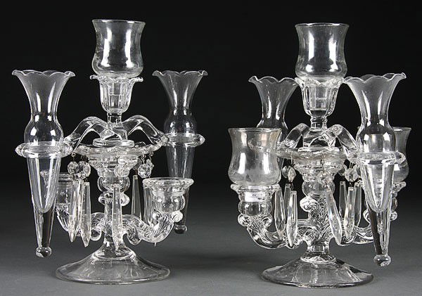 A PAIR OF CAMBRIDGE CRYSTAL CANDELABRA- EPERGNES,: A PAIR OF CAMBRIDGE CRYSTAL CANDELABRA- EPERGNES, 2nd quarter 20th century. Comprising scrolled arm bases with vase holders, candle lamps and cut prisms. Height 9 inches.