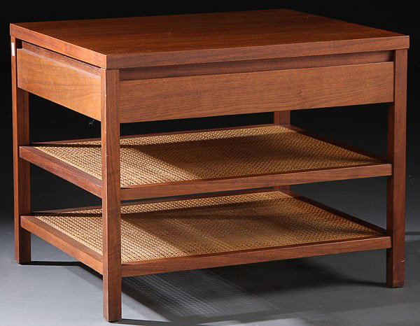 PAUL MCCOBB CALVIN FURNITURE WALNUT TABLE: A VERY FINE PAUL MCCOBB FOR CALVIN FURNITURE CO. MODERN WALNUT LAMP TABLE, CIRCA 1960. With single drawer raised on squared legs joined by two lower woven wicker shelves. Height 19 inches, width 24 in