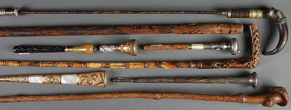 A COLLECTION OF THREE CANES AND SIX UMBRELLA HAND: A COLLECTION OF THREE CANES AND SIX UMBRELLA HANDLES, LATE 19TH/EARLY 20TH CENTURY. Comprising a carved ivory bamboo form walking stick/cane with stag horn handle, a folk art carved wood walking stick