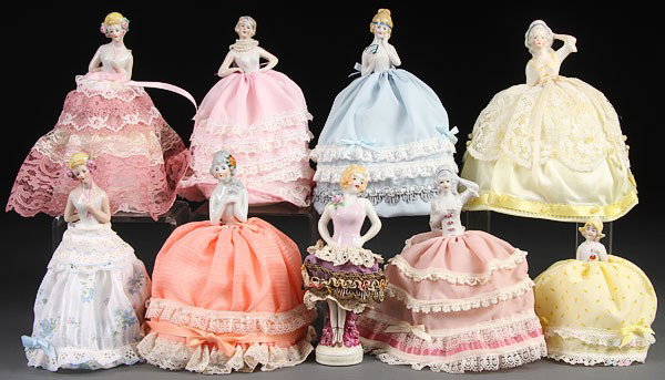 A COLLECTION OF GERMAN PORCELAIN HALF DOLL/PIN CU: A COLLECTION OF GERMAN PORCELAIN HALF DOLL/PIN CUSHIONS, EARLY 20TH CENTURY. Nine dolls of various size and pose, one with one with porcelain legged base. Height 5.5 inches to 8 inches.