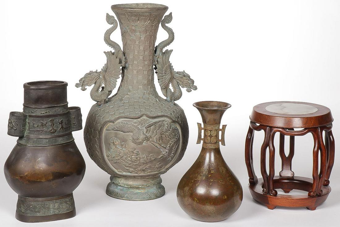 CHINESE AND JAPANESE BRONZE VASES: CHINESE AND JAPANESE BRONZE VASES. Comprising three bronze vases, the largest example with dragon handles (dent on side). Together with a wood drum form stand with marble insert. Greatest height 14.4