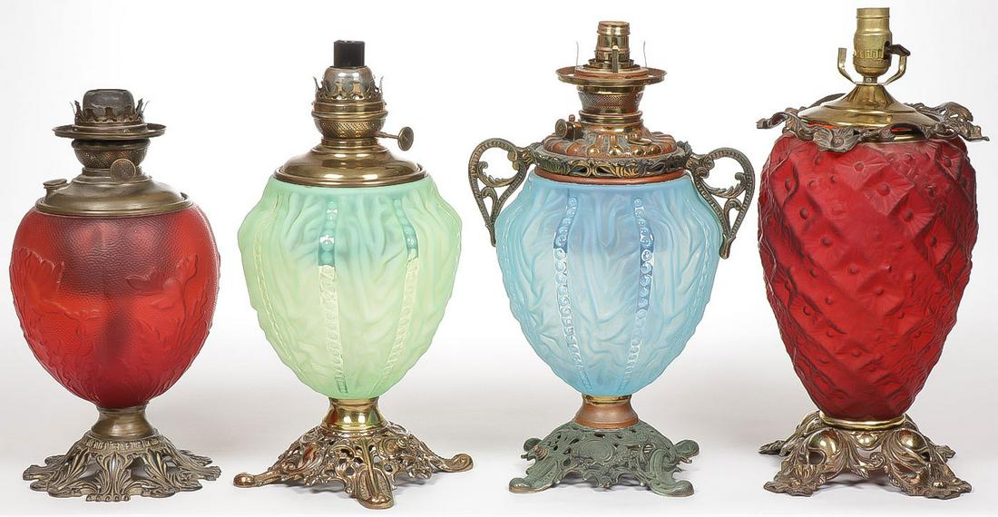 FOUR VINTAGE GLASS LAMP BASES: FOUR VINTAGE GLASS LAMP BASES. Comprising four individual kerosene lamp bases, different makers and patterns as shown. Each electrified. Greatest height 18.75 inches. SHIPPING NOTICE: Jackson's