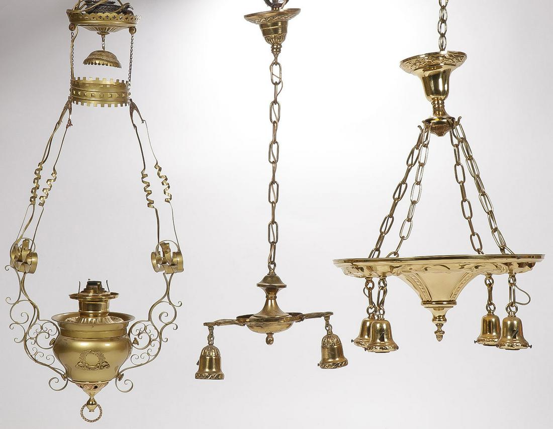 THREE VINTAGE BRASS HANGING LAMPS: THREE VINTAGE BRASS HANGING LAMPS. Including an electric converted kerosene hanging parlor lamp with adjustable chain for height (left), a two-light hanging lamp and chain, and an ornate polished 