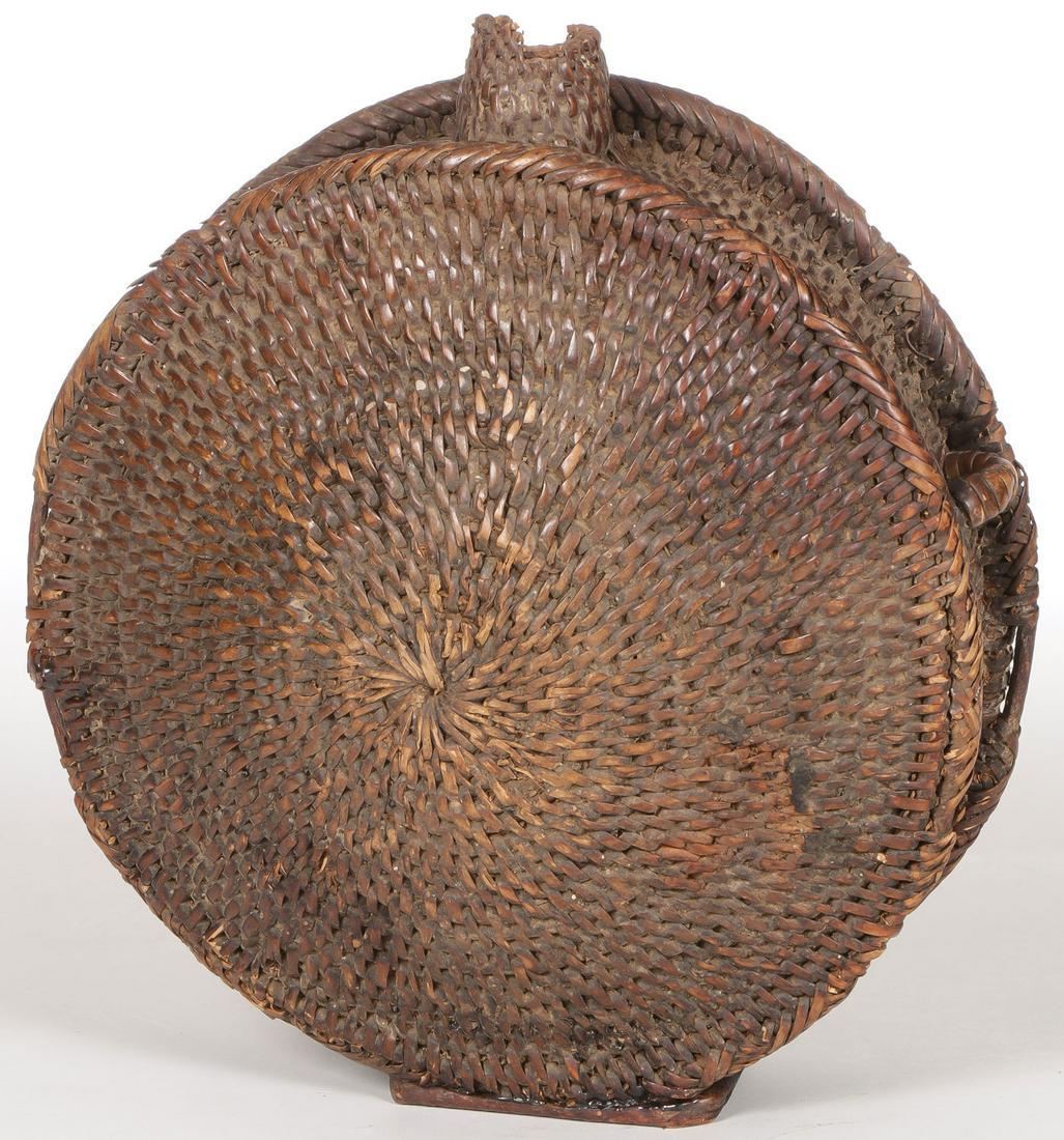 AN APACHE WOVEN CANTEEN: AN APACHE WOVEN CANTEEN Woven with integral square reed base, missing one lug and some loss to lip, otherwise a good example. Height 9 inches. SHIPPING NOTICE: Jackson's is your sole and only sour
