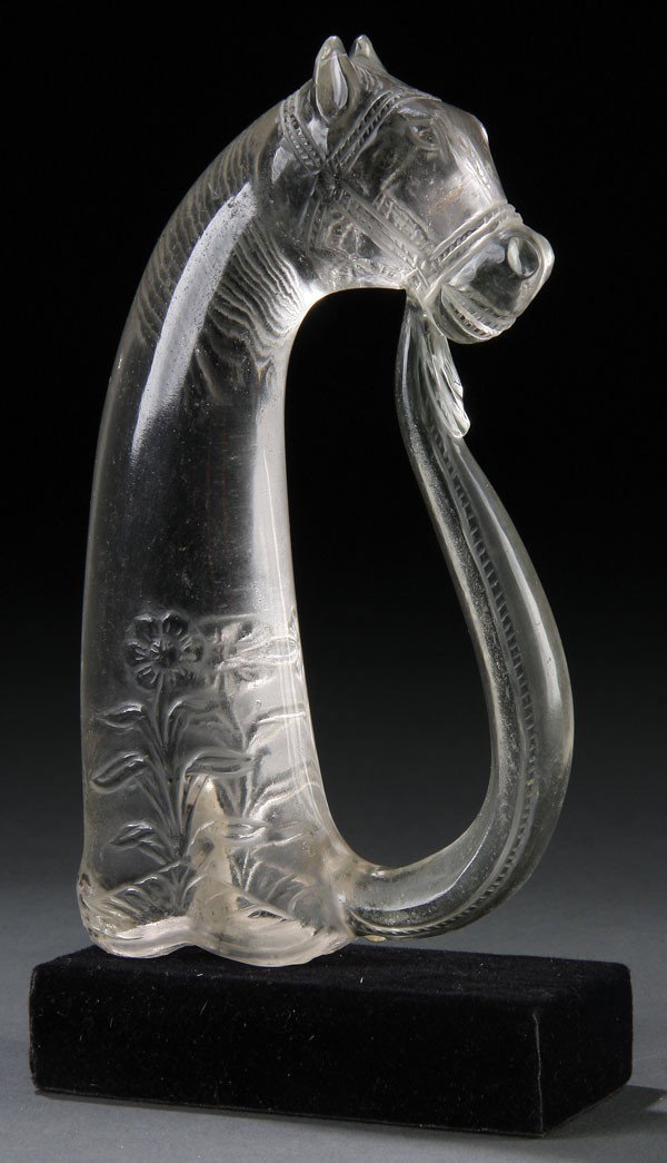 A CHINESE MUGHAL STYLE CARVED ROCK CRYSTAL HILT: A GOOD CHINESE MUGHAL STYLE CARVED ROCK CRYSTAL HORSE FORM SWORD HILT. In colorless rock crystal, the pommel carved in the form of a horse's head with scrolling guard, the base carved with a floral de