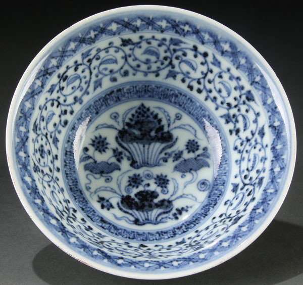A CHINESE XUANDE STYLE BLUE WHITE "FLOWERS" BOWL: A CHINESE XUANDE STYLE BLUE WHITE "FLOWERS" PORCELAIN BOWL. With gently sloping sides and everted rim decorated with blue scrolling florals under glaze. Blue rosette mark within foot rim. Small chip o