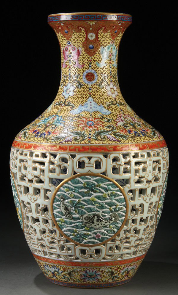 A FINE CHINESE DOUBLE WALL RETICULATED VASE: A CHINESE IMPERIAL QUALITY STYLE DOUBLE WALLED RETICULATED PORCELAIN VASE. Of baluster form finely enameled with scrolled lotus blossoms and Buddhist symbols on a yellow enameled ground with keyed dia
