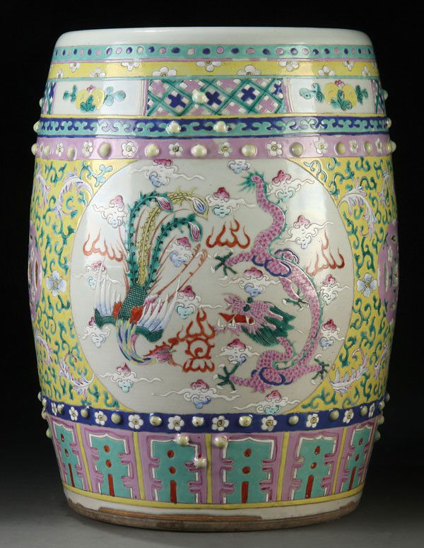 A CHINESE FAMILLE ROSE PORCELAIN GARDEN SEAT: A LARGE CHINESE FAMILLE ROSE PORCELAIN GARDEN SEAT, 20TH CENTURY. Of barrel form decorated with a scene of battling dragons and phoenix in two reserves on a yellow enameled ground with scrolled foliat