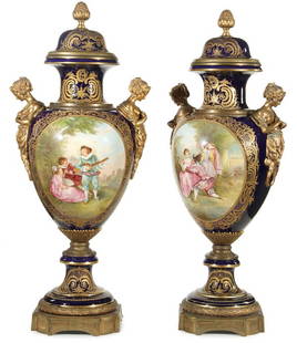 MASSIVE PAIR OF SEVRES STYLE GILT BRONZE URNS: A PAIR OF LARGE AND IMPRESSIVE SEVRES STYLE GILT BRONZE MOUNTED PORCELAIN URNS, 19TH CENTURY. Each side of the large cobalt blue ovoid form vases centered with a large cartouche encircled with raised