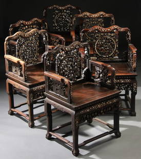 SIX CHINESE EXPORT CARVED ROSEWOOD ARMCHAIRS: A SET OF SIX CHINESE EXPORT CARVED ROSEWOOD AND MOTHER OF PEARL INLAID ARM CHAIRS, LATE 19TH/EARLY 20TH CENTURY. With carved open work backs decorated in a scene of foo lions, deer and phoenix inlaid