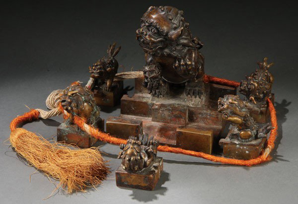 CHINESE FOO LIONS INTERLOCKING BRONZE PUZZLE SEAL: A FINE CHINESE FOO LIONS INTERLOCKING BRONZE PUZZLE SEAL, PROBABLY EARLY 20TH CENTURY, OR PERHAPS EARLIER. Comprising a seated foo lion with "embroidered ball" and embossed archaic type seal under bas